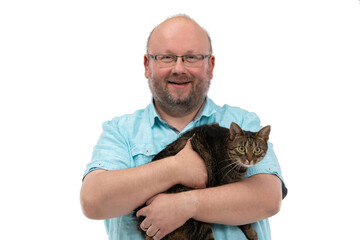 A bald man holds a she-cat in his arms and smiles.