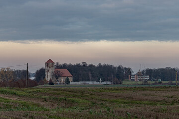 Naklejka na ściany i meble dark gloomy landscape with old church in Latvia countryside. Lestene church