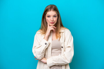 Teenager Russian girl isolated on blue background and thinking