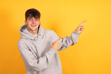 isolated teen boy pointing on background with space
