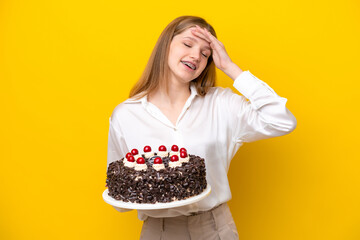 Teenager Russian girl holding birthday cake isolated on yellow background smiling a lot