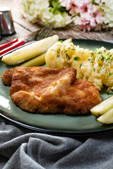 Pork chop served with mashed potatoes and pickled cucumber.