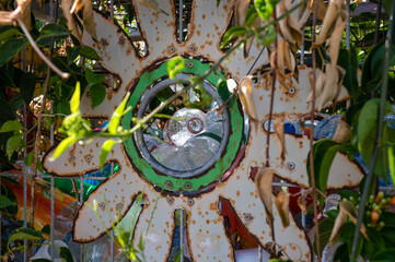 A lot of plastic empty bottles on the street in a container entwined with flowers