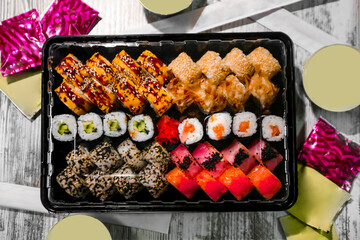 Assorted japanese sushi rolls on black background.