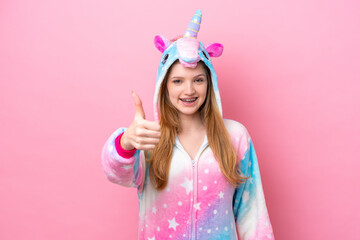 Teenager Russian girl with unicorn pajamas isolated on pink background with thumbs up because something good has happened