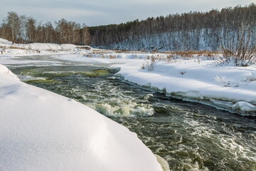 Dry grass close-up on the background of white snow in winter