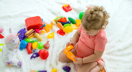 Baby plays with toys in her room. Selective focus.