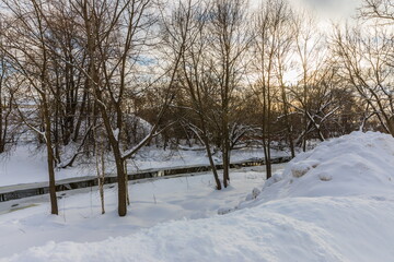 Fototapeta na wymiar The Vokhonka river in winter in the historical center of the small district town of Pavlovsky Posad, Russia