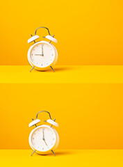 classic alarm clocks showing nine and five over a yellow background