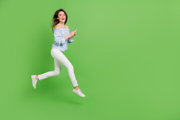 Fototapeta na wymiar Photo of impressed lady dressed blue checkered blouse jumping running reading device empty space isolated green color background