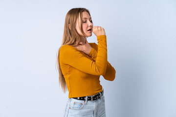 Teenager Ukrainian girl isolated on blue background coughing a lot