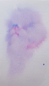 Background with abstract ink stains made with watercolor in blue, purple and pink colors on textured paper