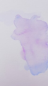 Background with abstract ink stains made with watercolor in blue, purple and pink colors on textured paper