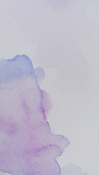 Background with abstract ink stains made with watercolor in blue, purple and pink colors on textured paper