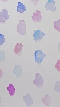 Background with small ink blots made with watercolor in blue, purple and pink colors on textured paper