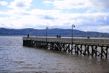 The wooden pier with the black lamps on the brown river