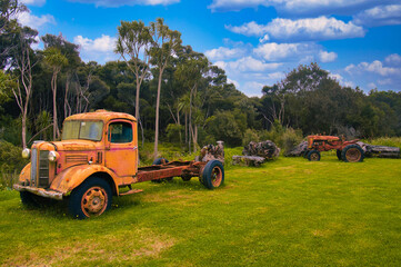 Abandoned vintage truck and tractor in a field in Northland, New Zealand
