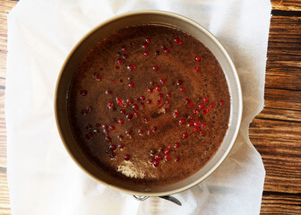 raw vegan brownie chocolate cupcakes with red currants in a metal mold. before the other. top view. gluten- and lactose-free pastries