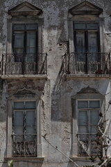 Fototapeta na wymiar Long bandoned townhouse chipped facade-closed balconies and balconets-metal railings. Tavira-Portugal-094