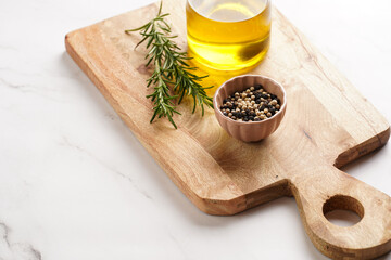 Cooking ingredients: olive oil, fresh rosemary, milk, pepper on wooden board