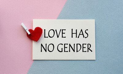 An open envelope with the text LOVE HAS NO GENDER, on a pink and blue background with a decor of felt hearts and a flower. Flat lay, top view. LGBT concept.