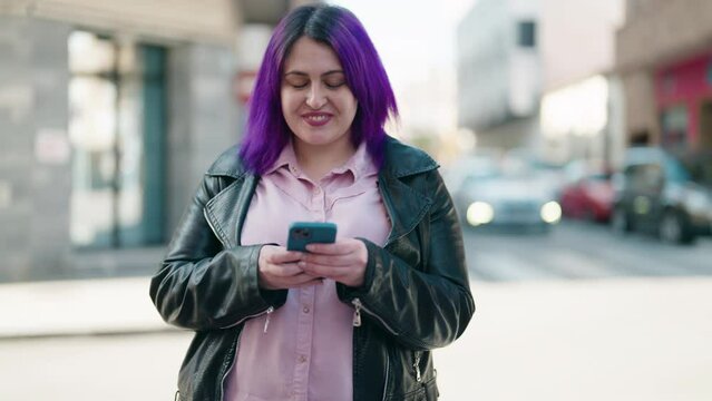 Young plus size woman smiling confident using smartphone at street