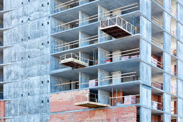 Construction of brick external walls and partitions in a new building with a gray concrete frame. - Powered by Adobe