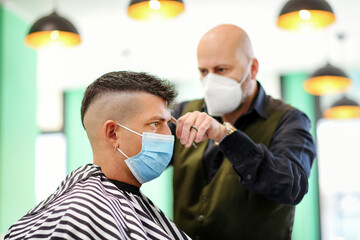 Professional barber wearing a mask during the Covid-19 pandemic