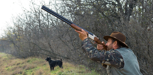 Hunter man in camouflage with a gun during the hunt in search of wild birds or game. Autumn hunting...