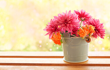 Spring flowers in a bucket on a wooden table with copy space.