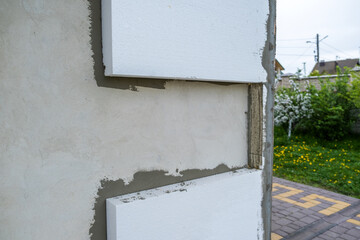 Installation of styrofoam insulation sheets on house facade wall for thermal protection