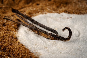 une gousse de vanille sur du sucre blanc et du sucre roux - 486366502