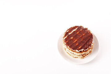 round tiramisu lies on a round plate on a white background with copy space