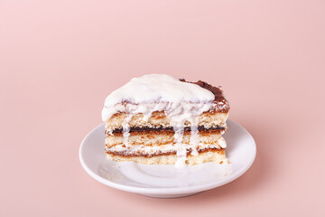 one piece of tiramisu with dripping cream on pink background with copy space