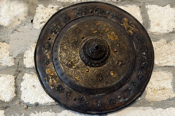 Aged ceremonial shield with repousse and chasing
