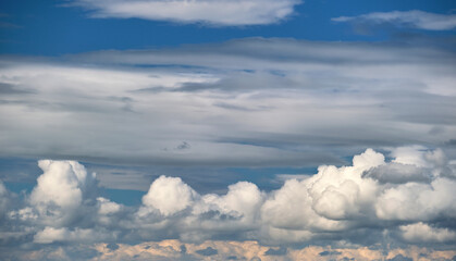 Bright landscape of white puffy cumulus clouds on blue clear sky