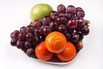 fruit on a plate. Bunch of grapes and tangerines