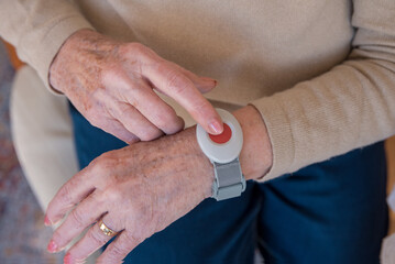 Senior hand pushing emergency call button - 486369526