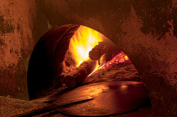 wood oven being prepared for the production of pizzas and calzones