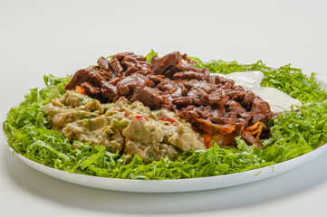 filet mignon in strips with sauce served with guacamole and curds and chopped lettuce