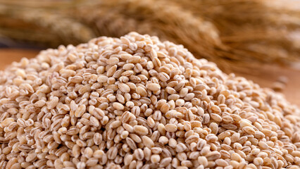 Raw organic Pearl barley on wooden board