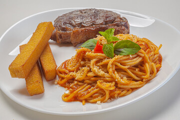 spaghetti in sugo sauce with parmesan served with filet and fried polenta