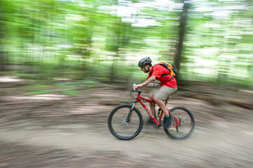 Fototapeta premium Man mountain biking captured in panning mode