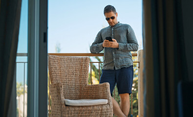 Man on the balcony using smartphone.