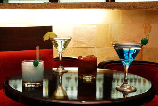 Cocktails, four refreshing cocktails on a table inside a bar, drinks prepared in a warm atmosphere