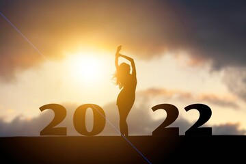 Silhouette freedom happy human enjoying on the hill and 2022 years while celebrating new year,
