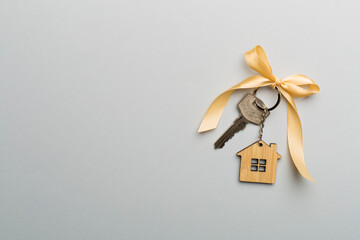House key with golden bow on color background