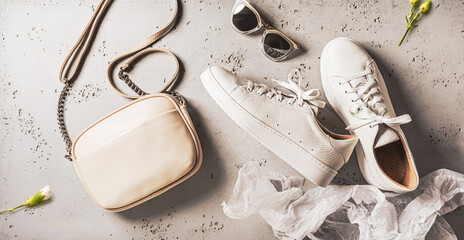 Spring fashion accessories for woman. White sneakers shoes, handbag and sunglasses.