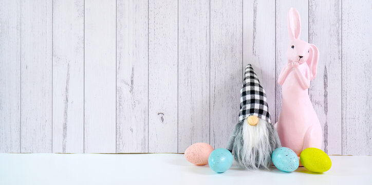 Happy Easter farmhouse theme banner styled with cute pink bunny, eggs and buffalo plaid gnome against a white wood background. Sized to fit popular social media and web banner.