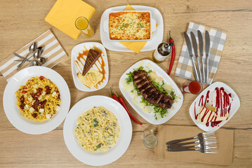 Hot dishes with pasta, cheese, vegetables and meat